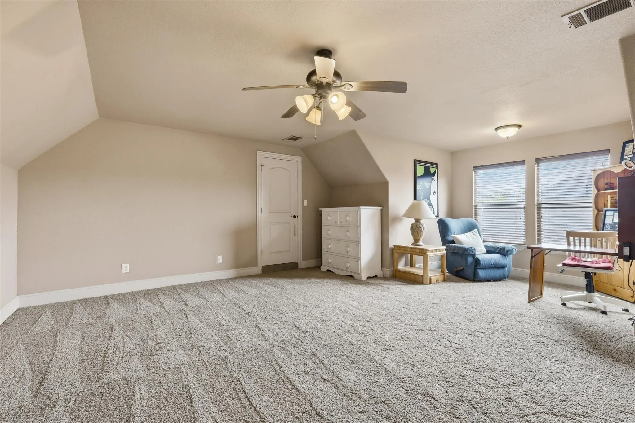 Additional living space featuring vaulted ceiling, a ceiling fan, and light carpet