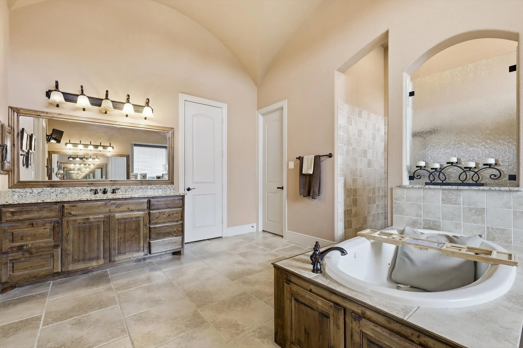 Bathroom featuring vanity, a tile shower, a bath, and vaulted ceiling
