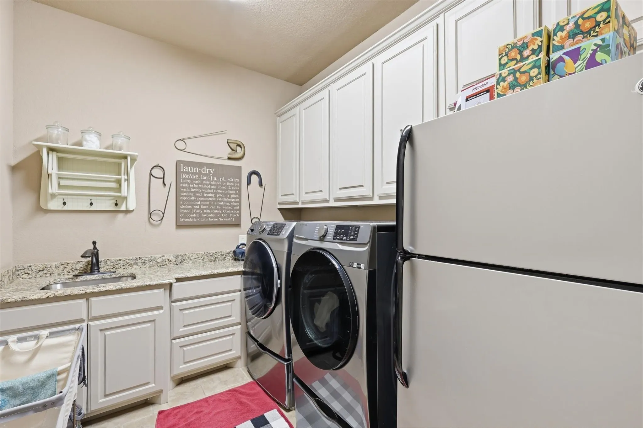 Laundry room featuring cabinet space, washer and dryer, and light tile patterned floors