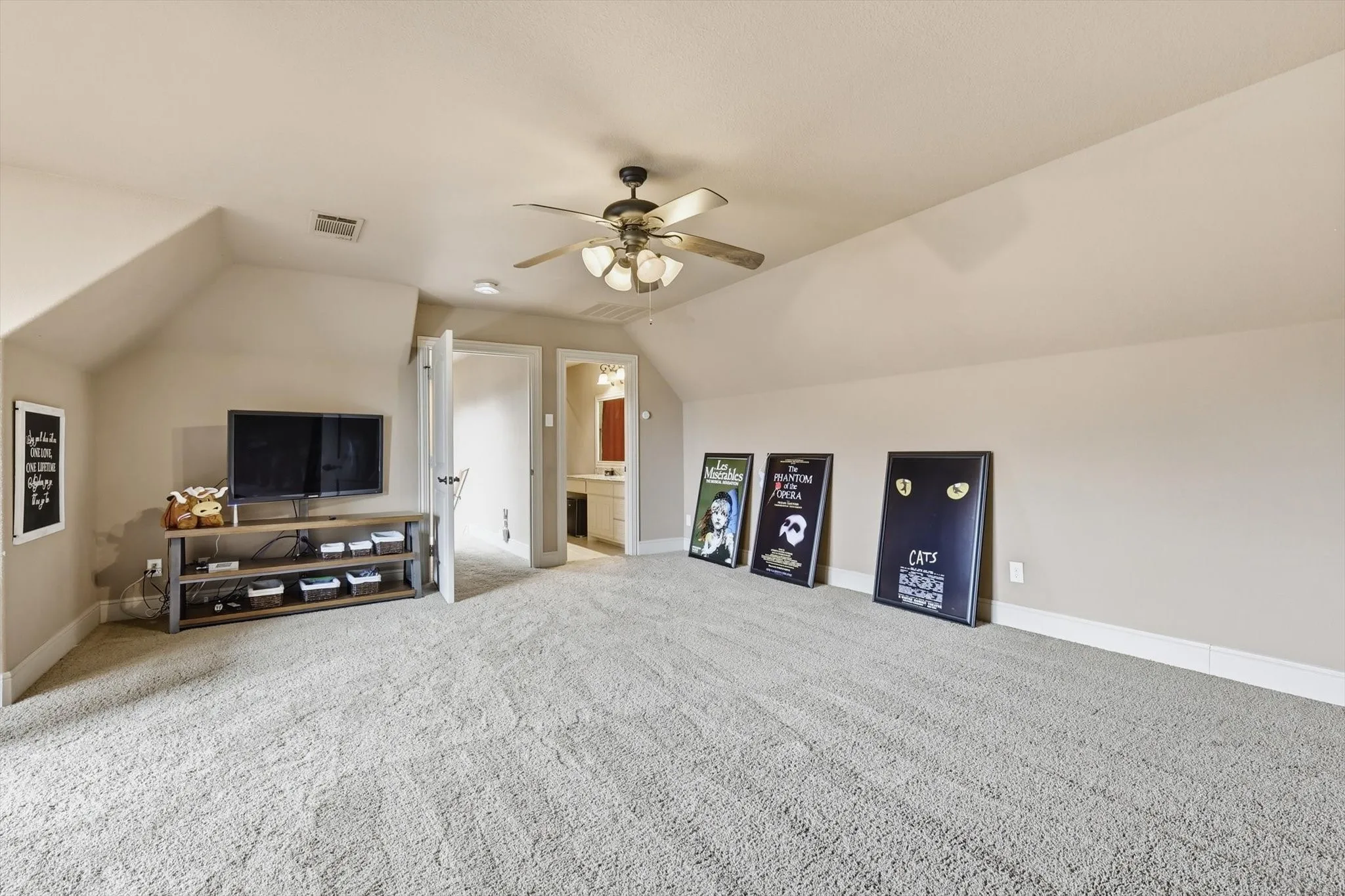 Additional living space featuring vaulted ceiling, ceiling fan, and light carpet