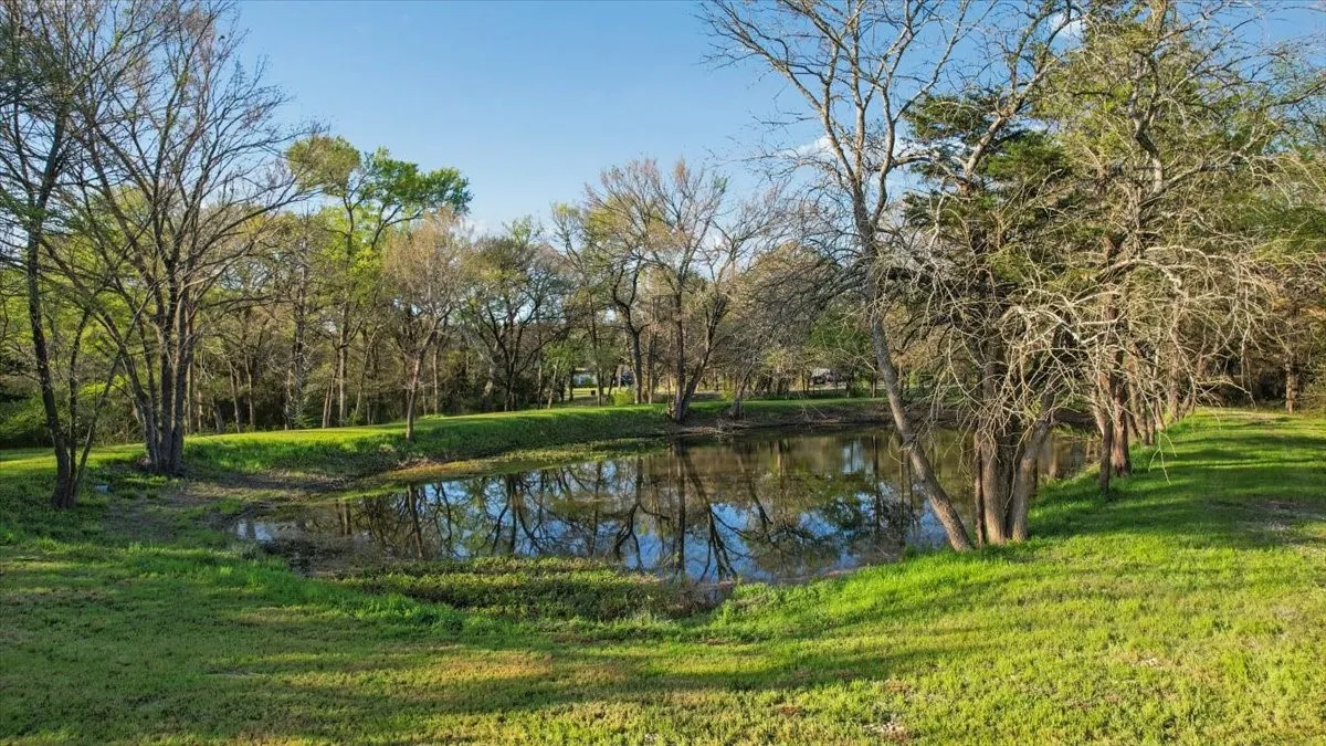 Gorgeous pond has rock road outlining pond