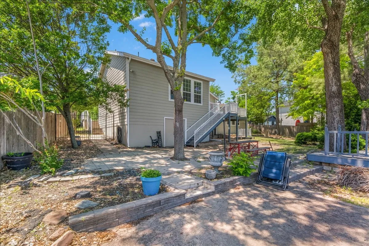Back of house with a fenced backyard, a patio, and a wooden deck