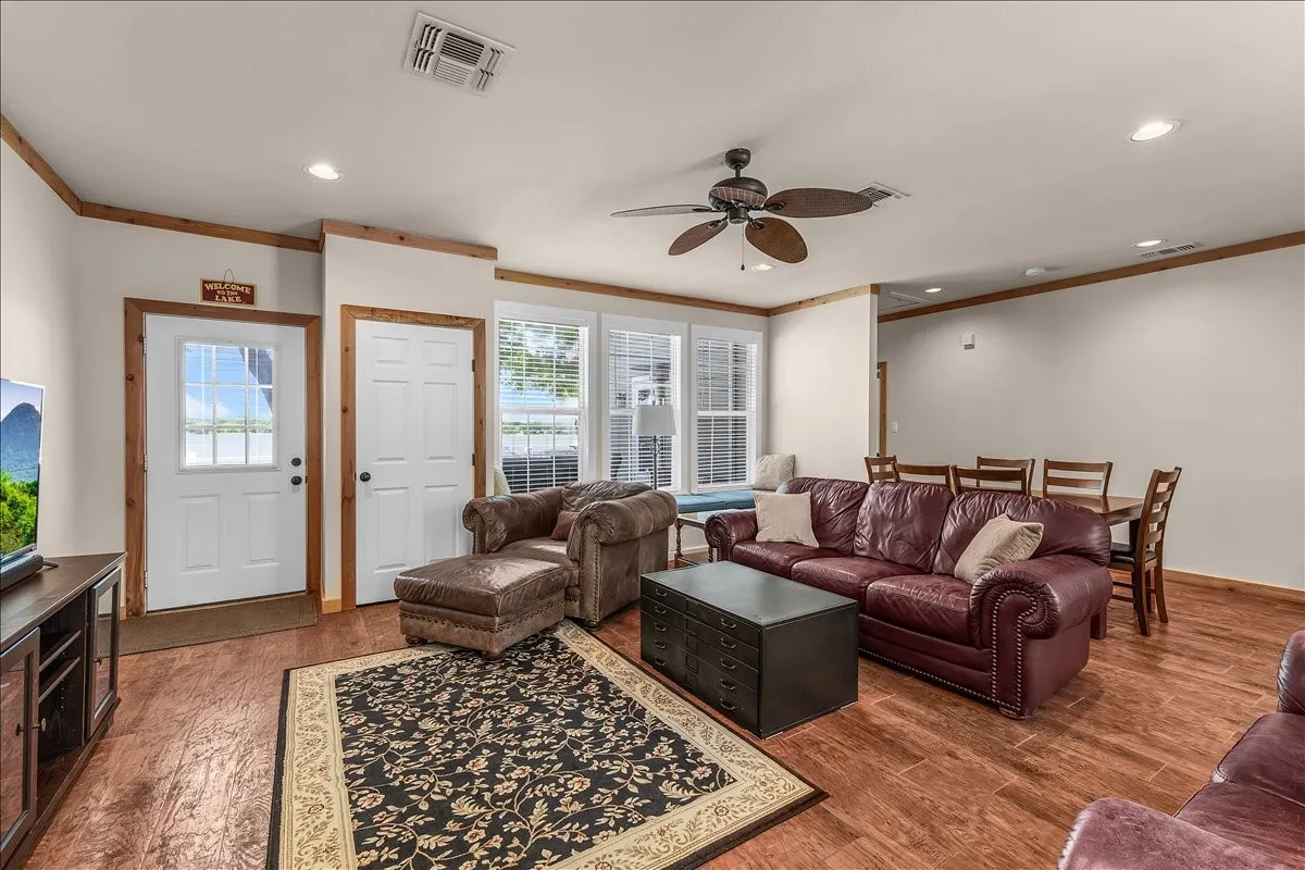 Living area featuring a ceiling fan, dark wood-type flooring, ornamental molding, and recessed lighting