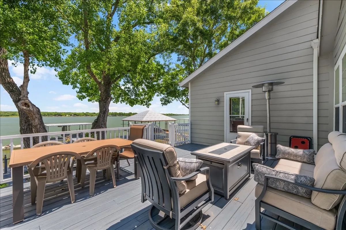 Deck with a water view, outdoor lounge area, and an outdoor fire pit