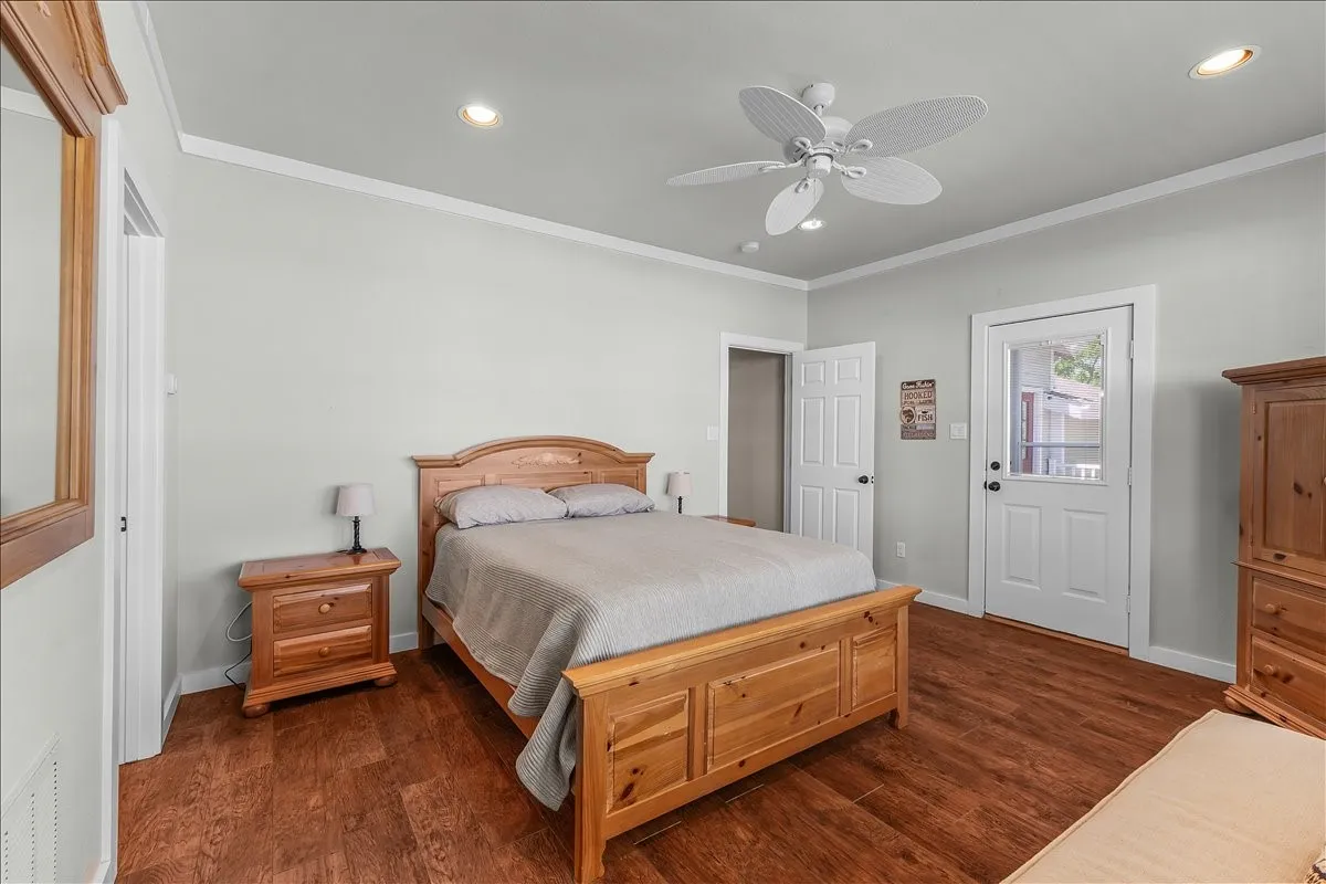Bedroom with ornamental molding, dark wood-type flooring, recessed lighting, and a ceiling fan