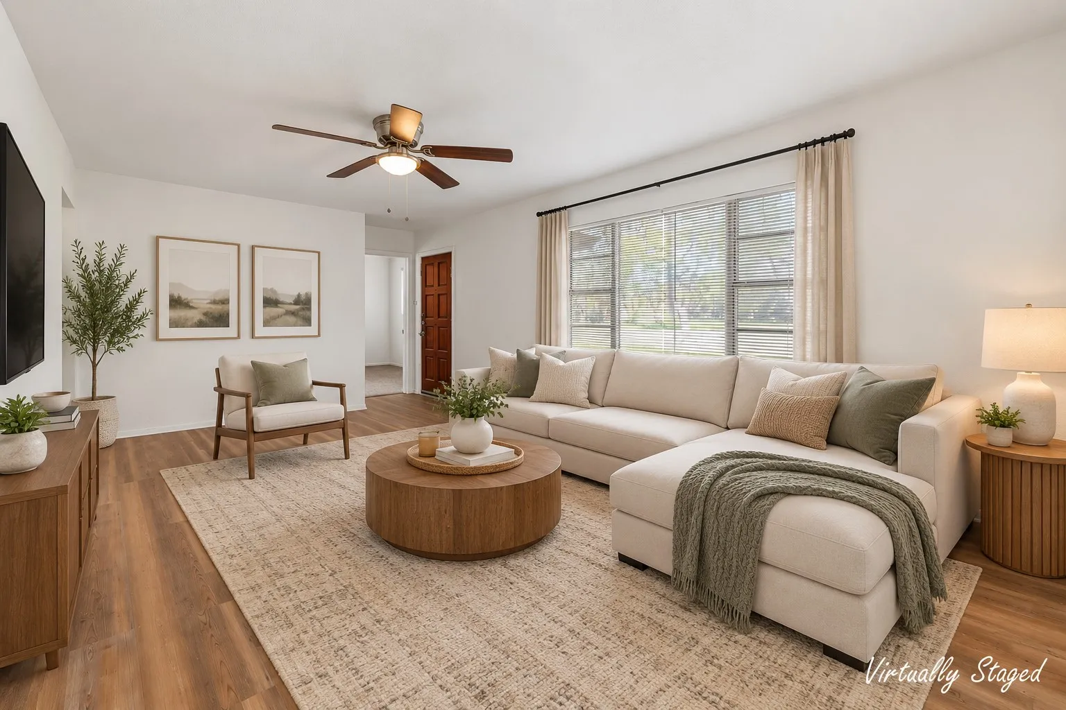 Spacious living area featuring wood-finish flooring, large windows, and a ceiling fan with integrated lighting Virtually staged