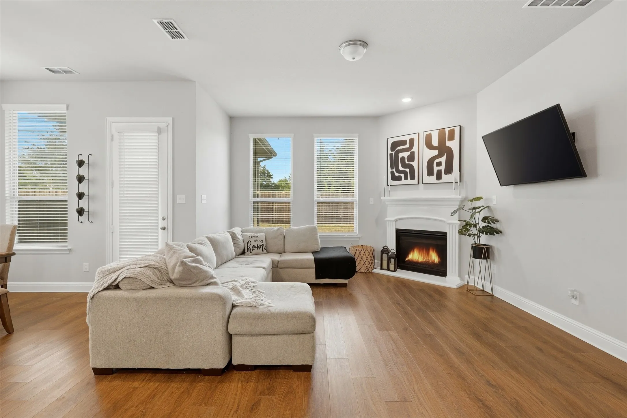 Living area with a glass covered fireplace and wood finished floors