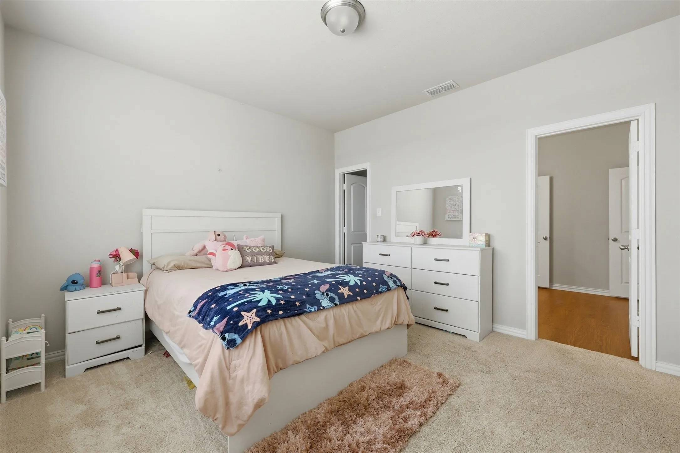 Bedroom featuring light carpet and baseboards