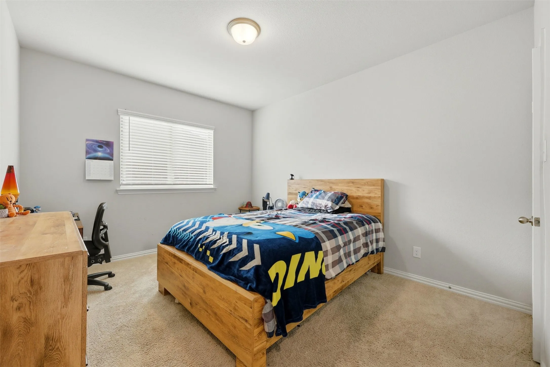 Bedroom with light carpet and an office area