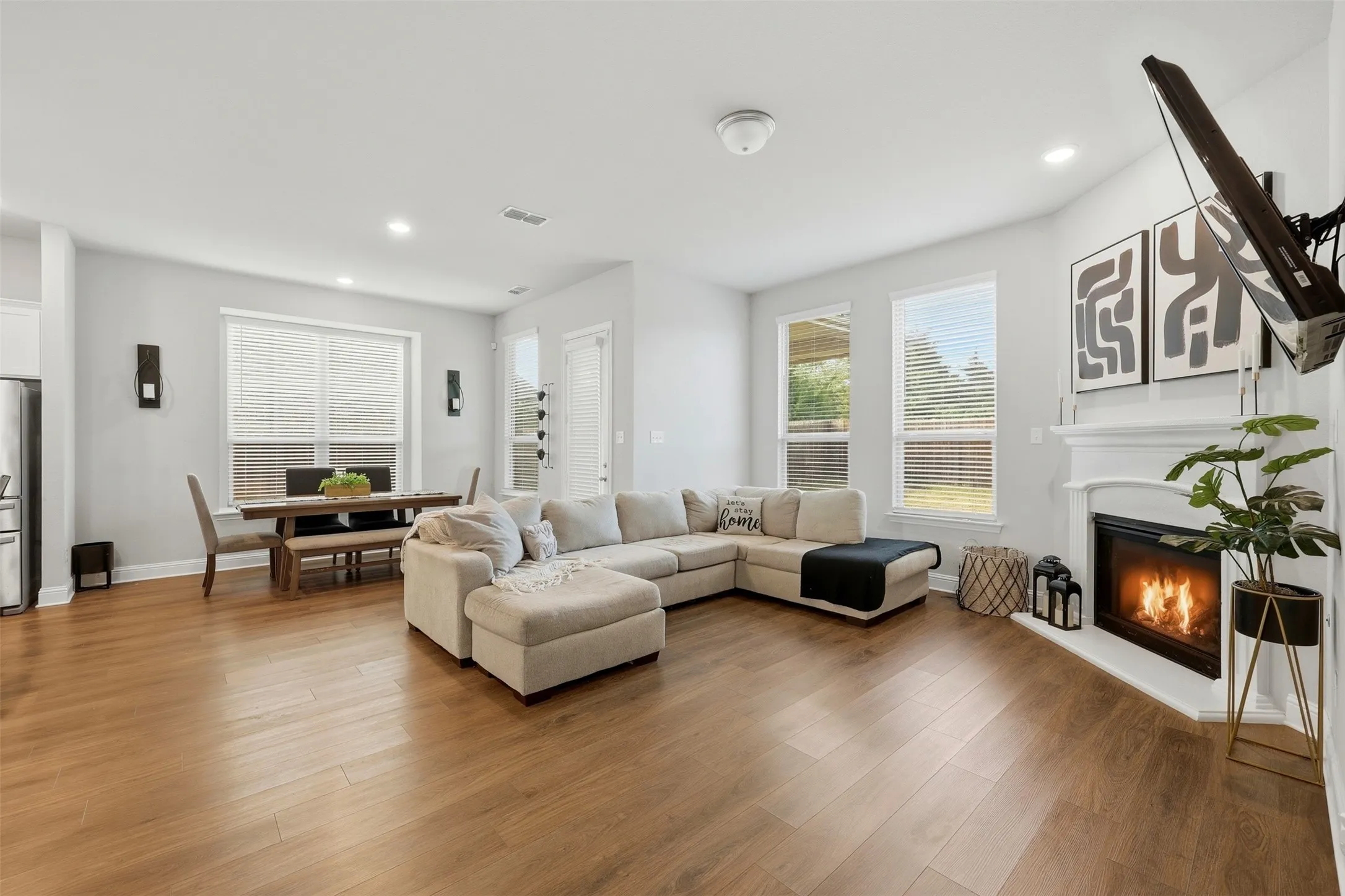Living area featuring wood finished floors, a glass covered fireplace, and recessed lighting