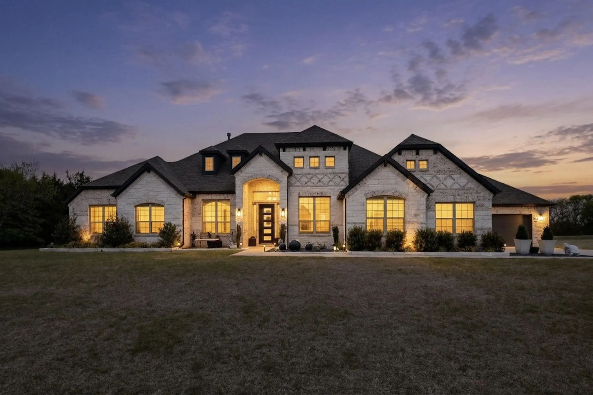 French provincial home featuring stone siding and a front yard