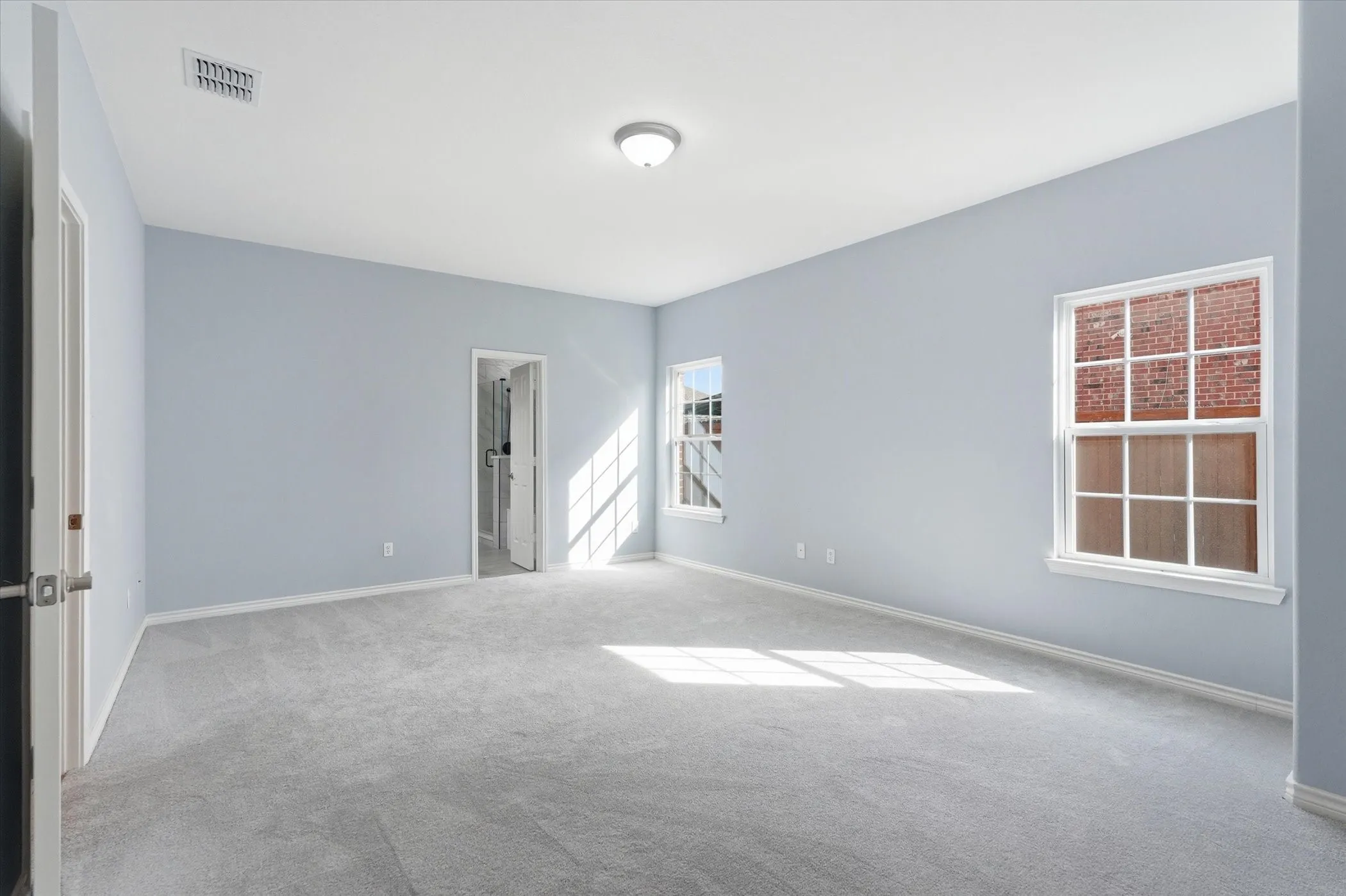 Unfurnished room with light colored carpet and baseboards