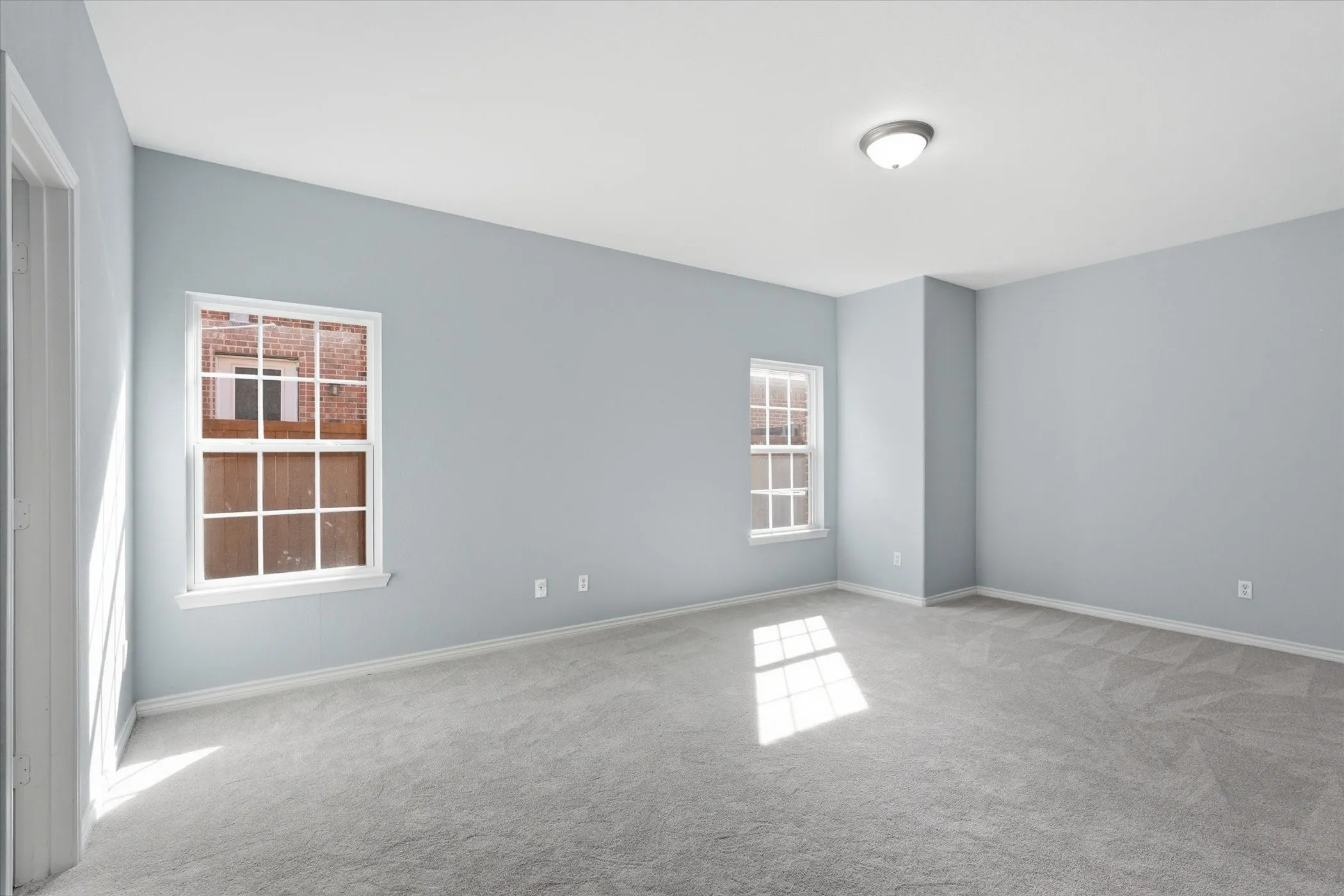 Empty room featuring light carpet and baseboards