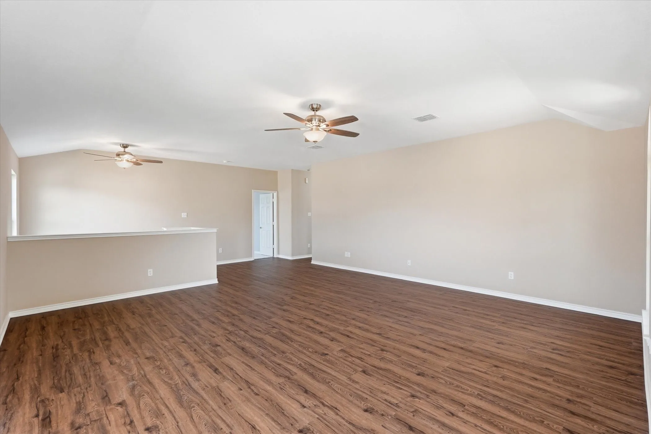 Unfurnished room with vaulted ceiling, a ceiling fan, and dark wood finished floors