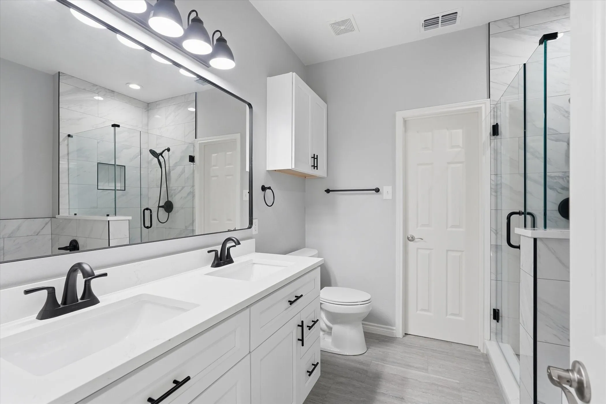 Bathroom featuring double vanity and a stall shower