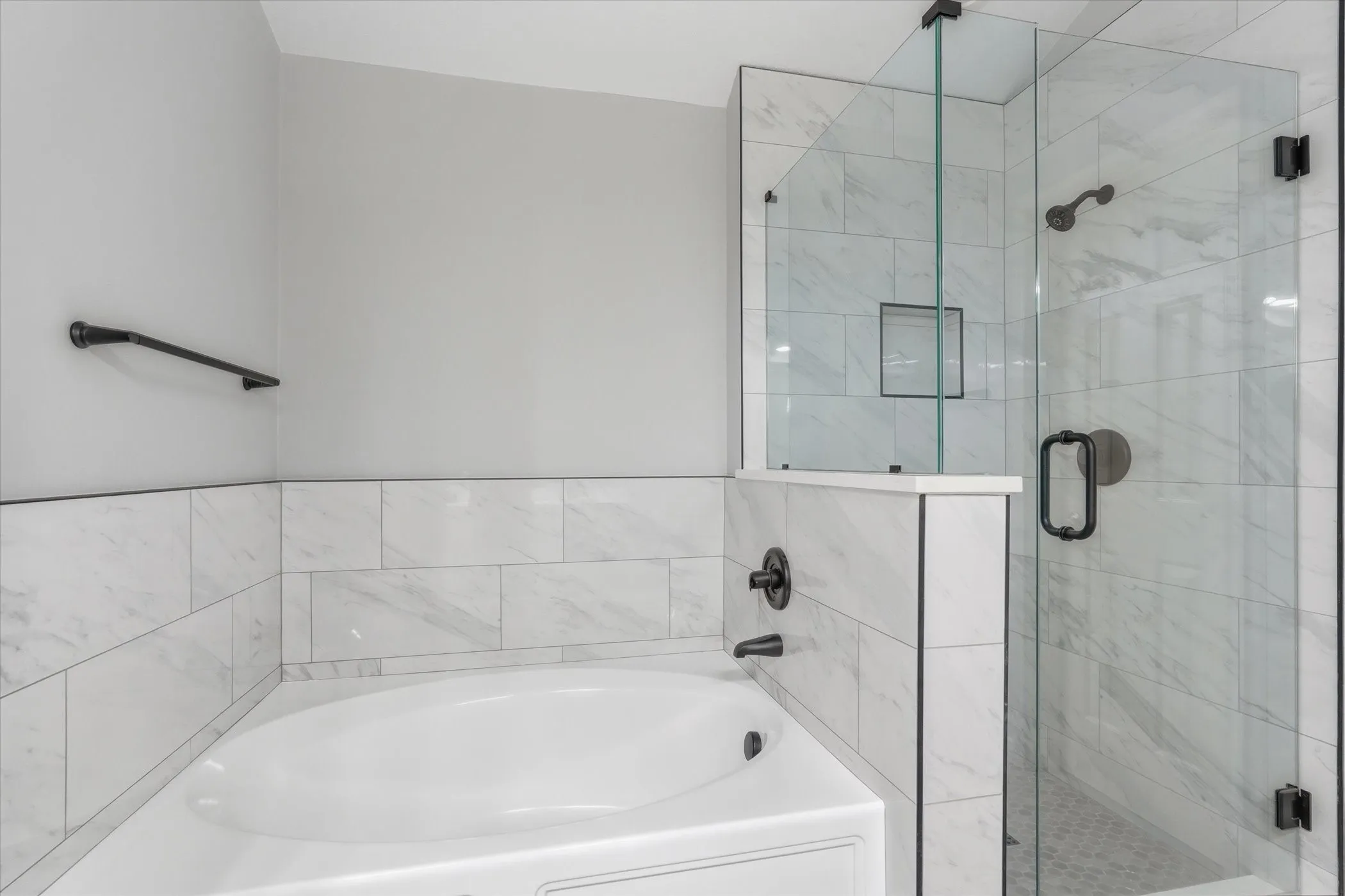 Bathroom featuring a shower stall and a bath