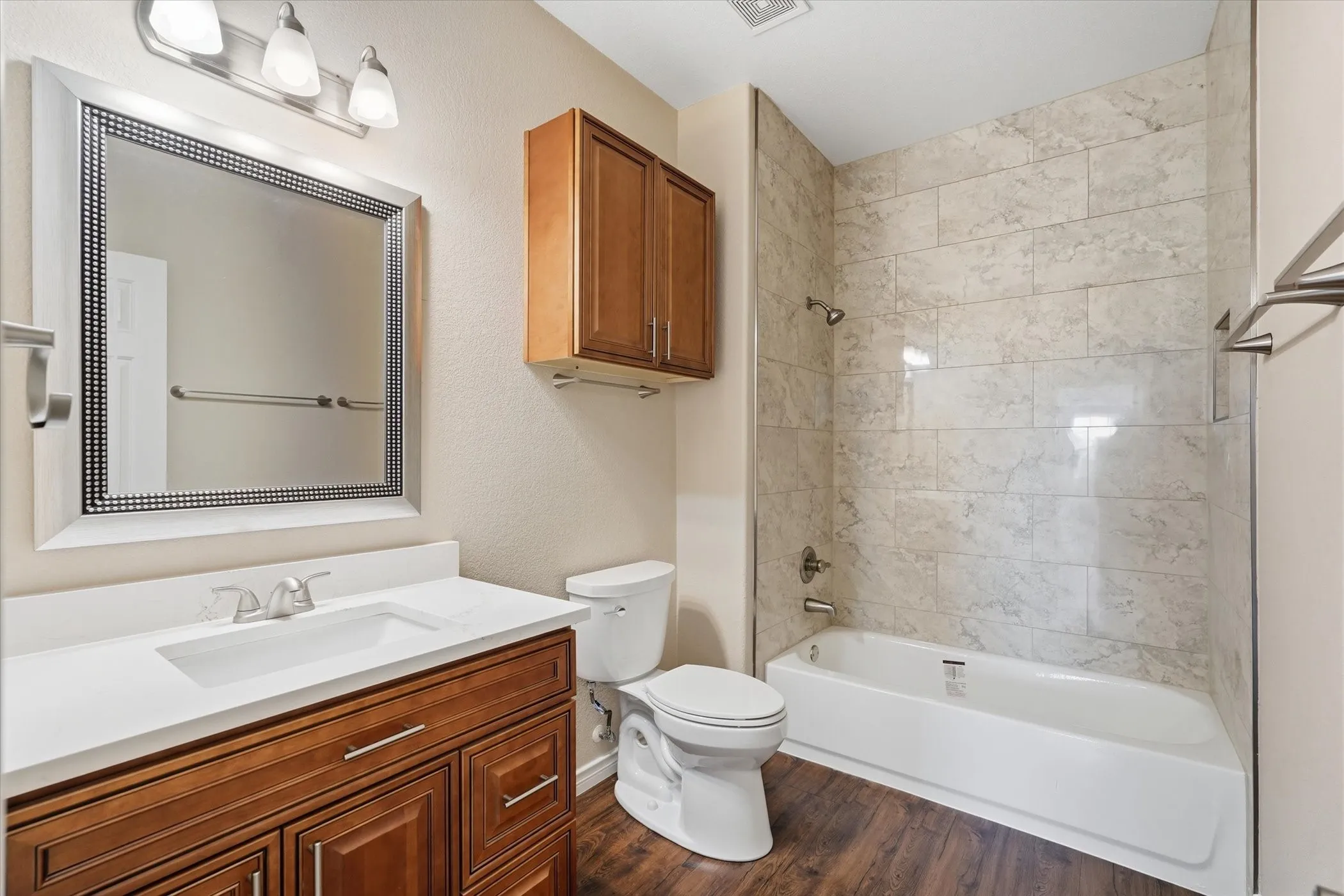 Bathroom with vanity,  shower combination, and dark wood-style flooring