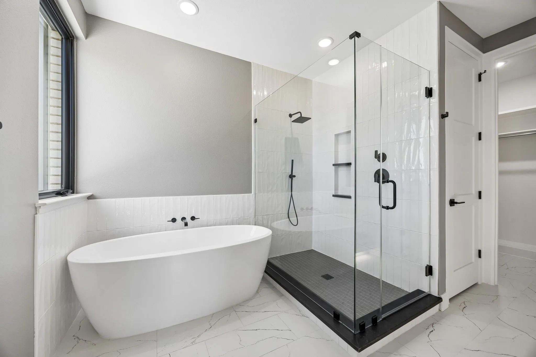 Full bathroom featuring a soaking tub, a stall shower, recessed lighting, light marble finish floors, and a wainscoted wall