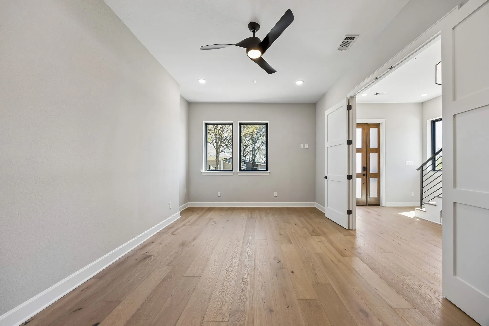 Empty room with a ceiling fan, light wood-style flooring, and recessed lighting