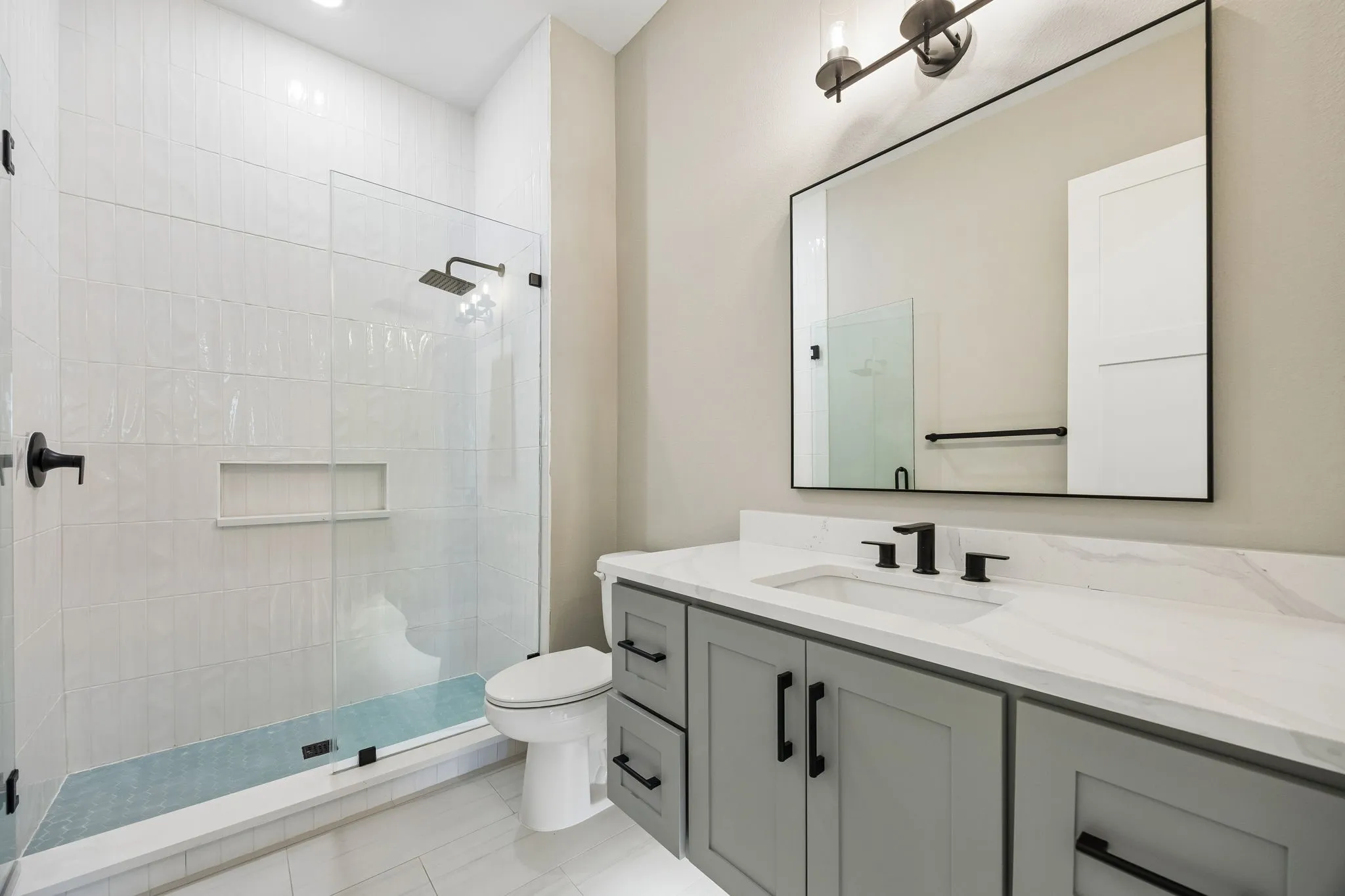 Bathroom featuring vanity, tiled shower, and recessed lighting
