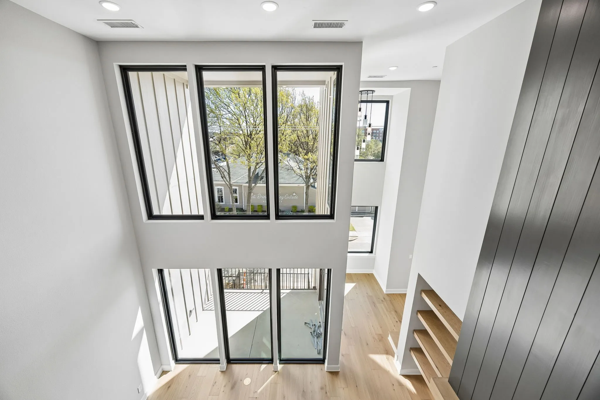 Stairway with wood finished floors and recessed lighting