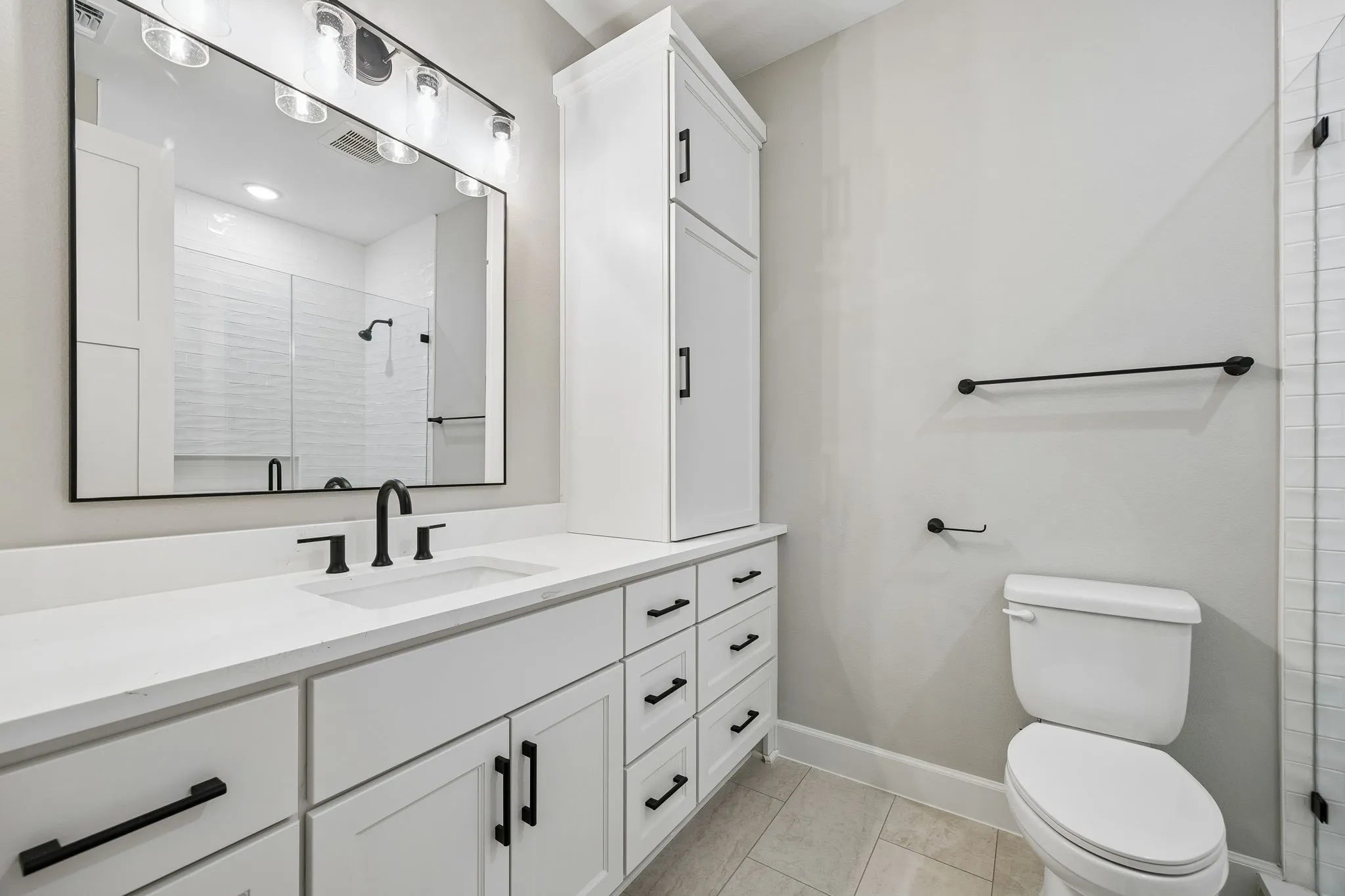 Full bathroom featuring vanity, a shower stall, and light tile patterned flooring