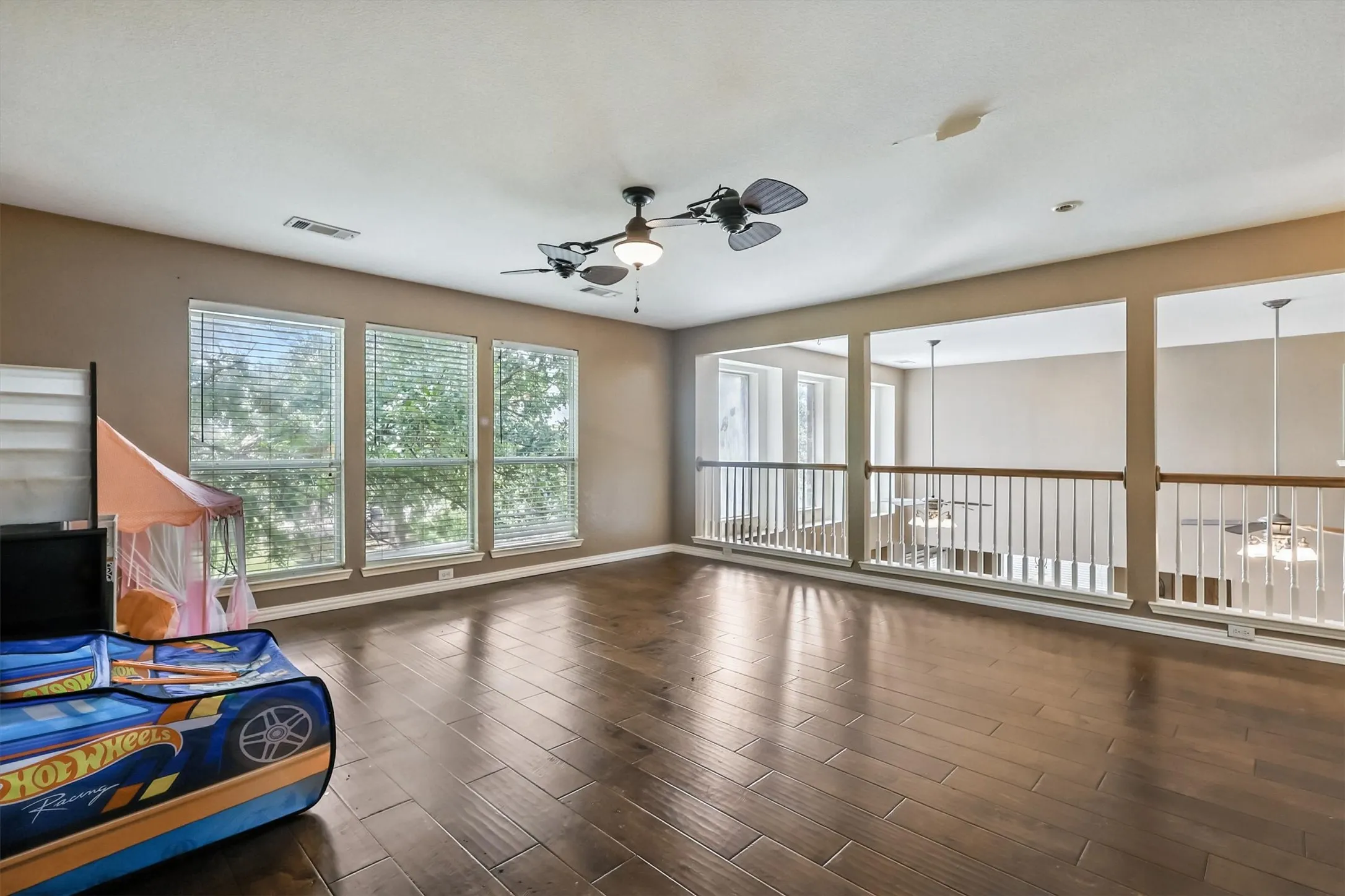 Living area with ceiling fan and wood finished floors
