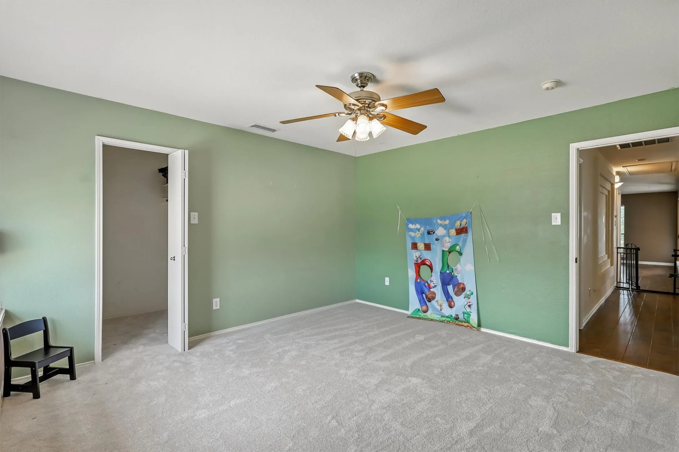 Bedroom 4 with carpet, a spacious closet, and ceiling fan