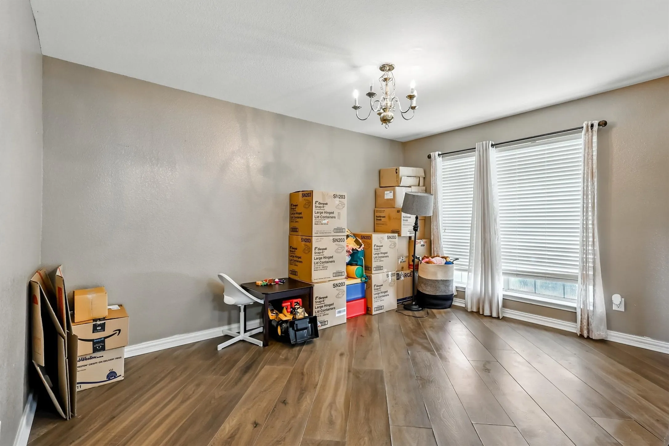Misc room with a chandelier and wood like floors