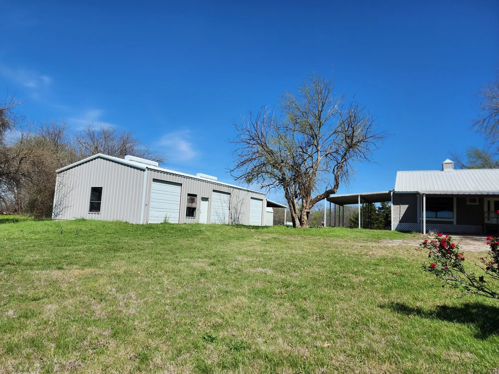 View of grassy yard with an outbuilding and a detached garage