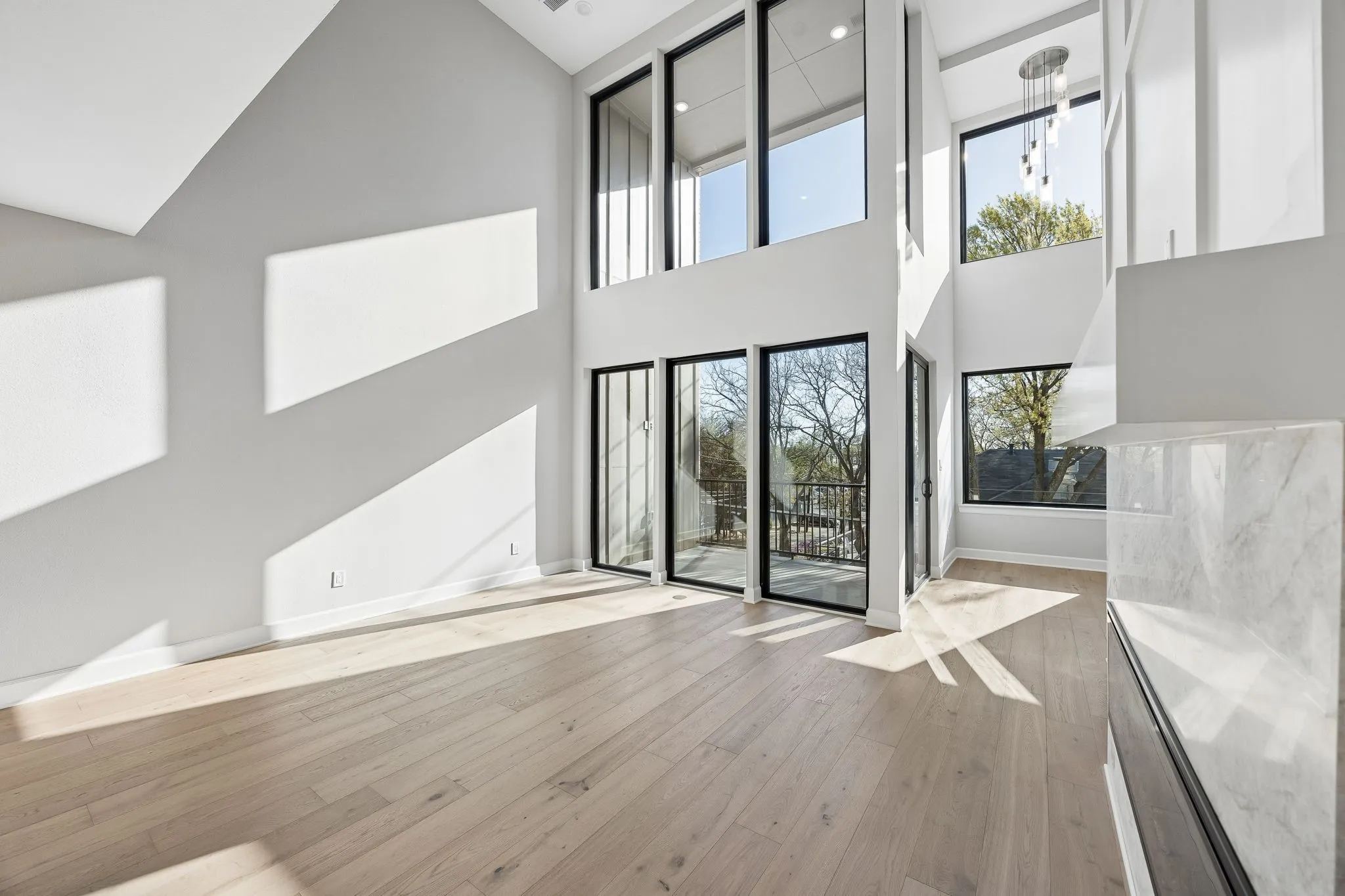 Unfurnished living room featuring light wood-style flooring and lofted ceiling