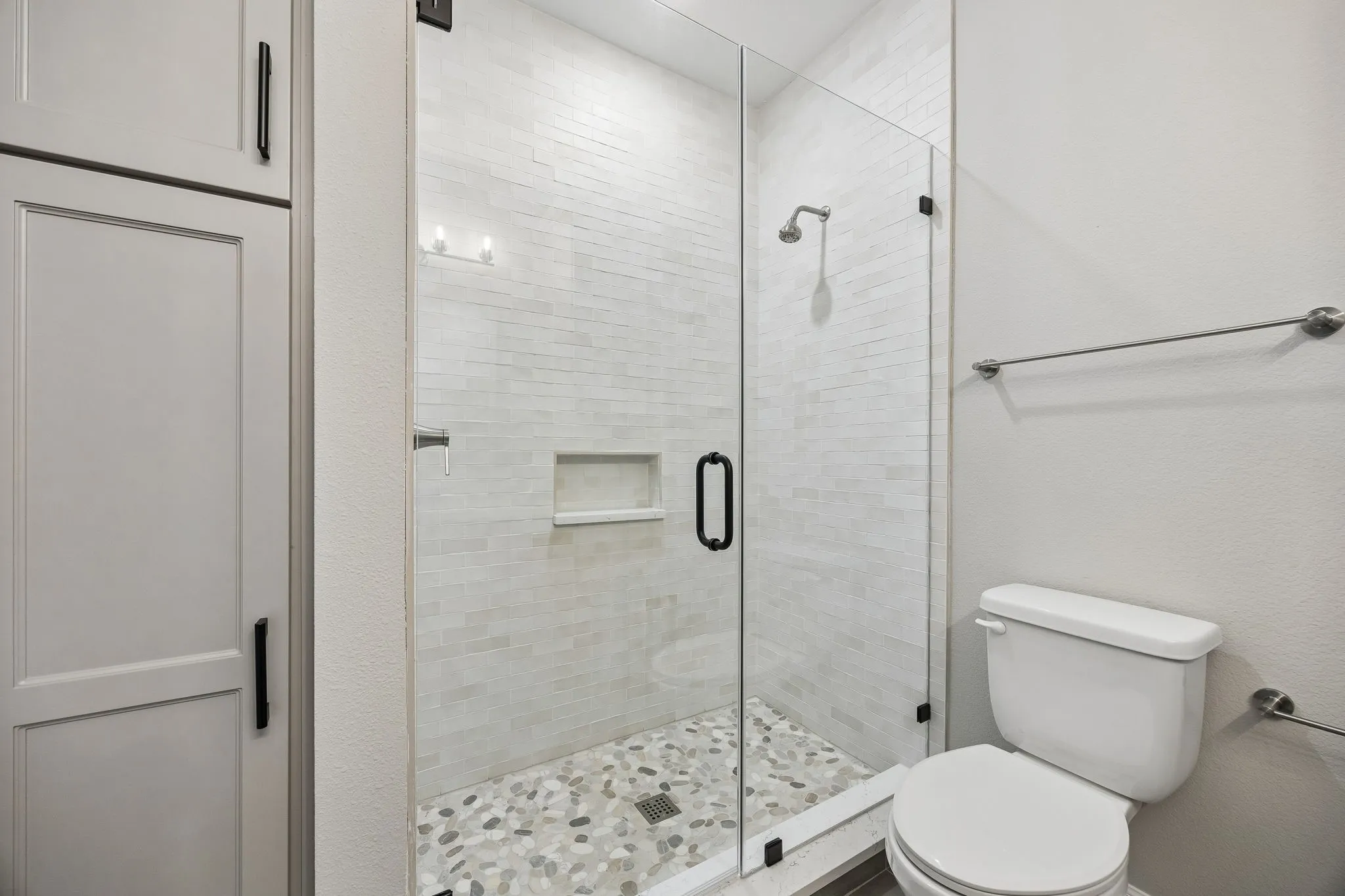 Full bathroom with toilet and a shower stall