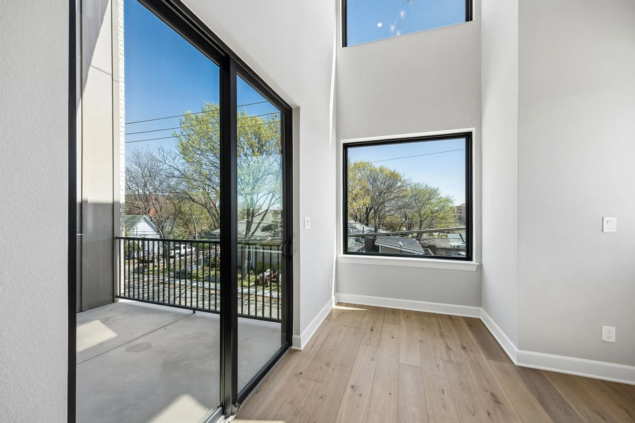 Doorway to outside with wood-type flooring, a high ceiling, and plenty of natural light