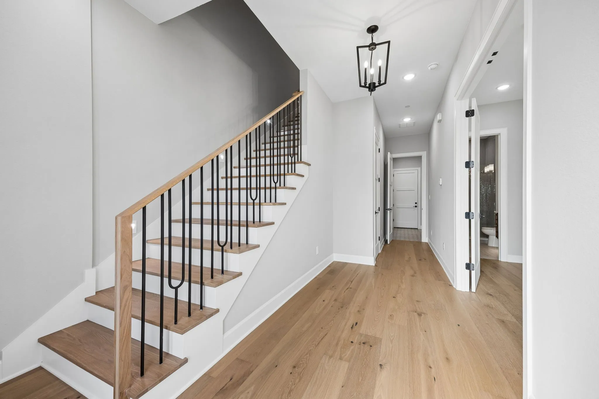Staircase featuring hardwood / wood-style flooring and a chandelier