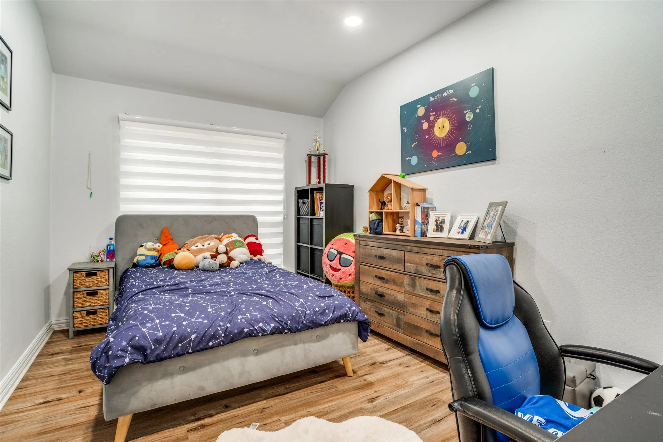 Bedroom featuring wood finished floors, a desk, and lofted ceiling