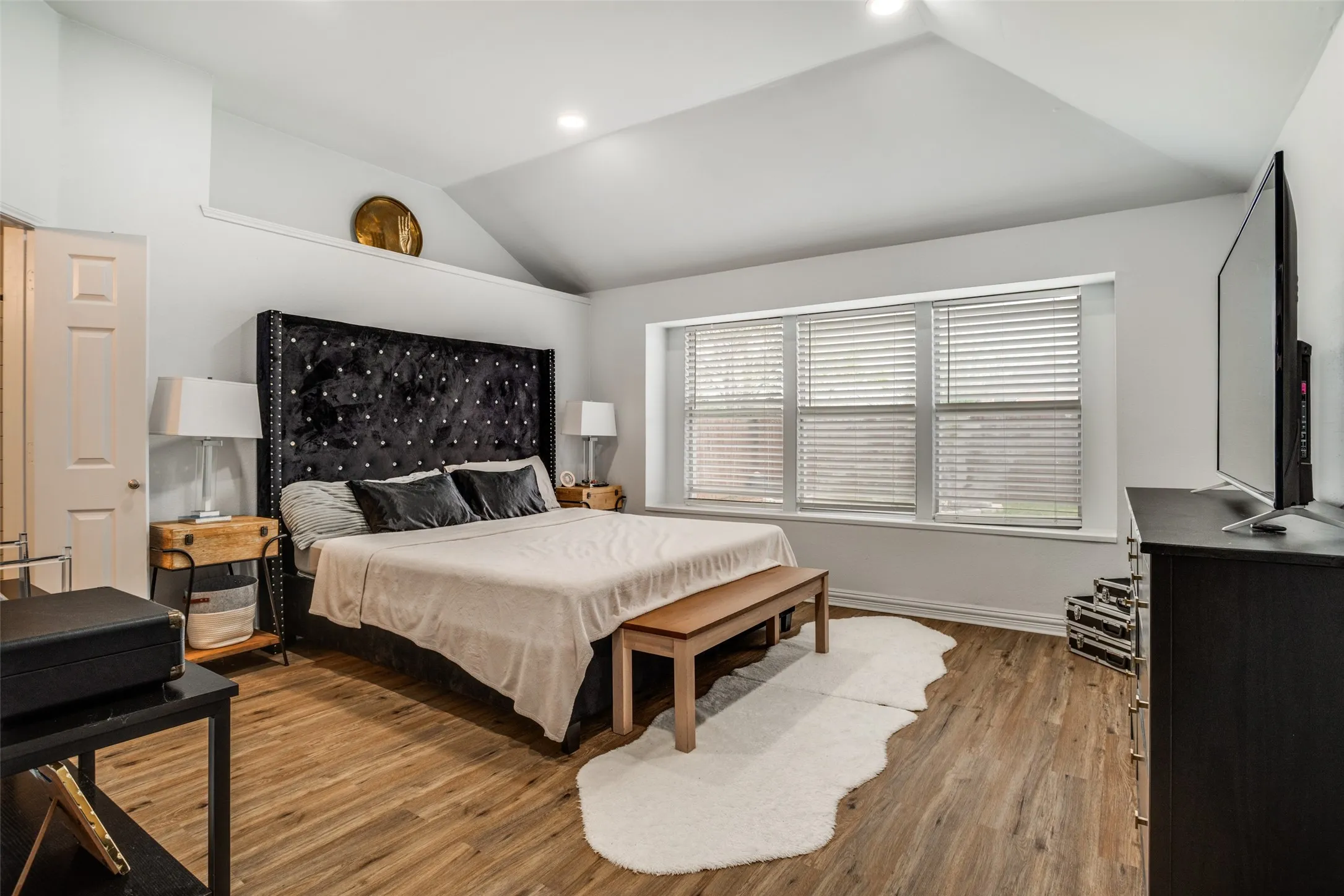 Bedroom with vaulted ceiling, light wood-style flooring, and recessed lighting