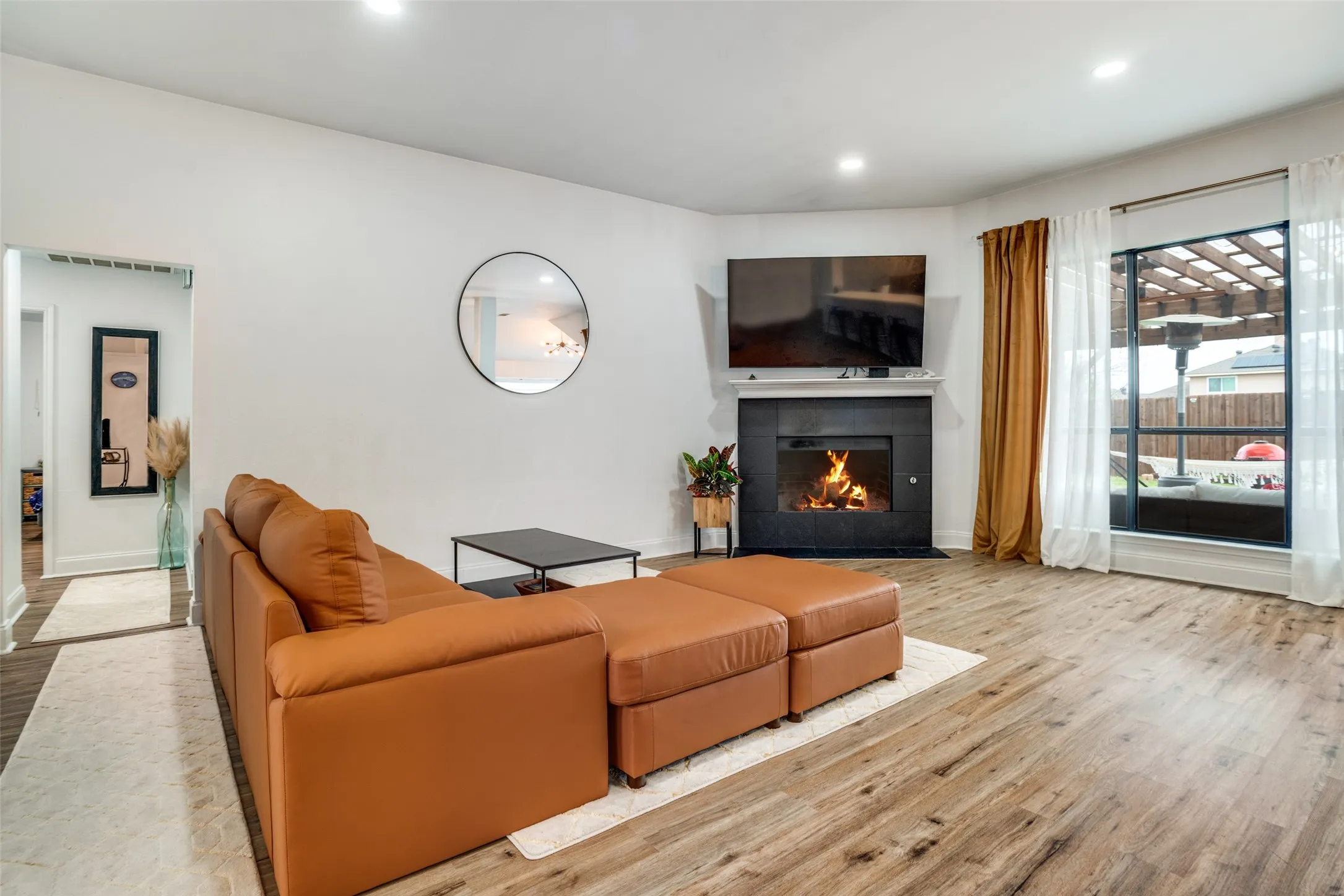 Living room featuring light wood finished floors, a fireplace, and recessed lighting