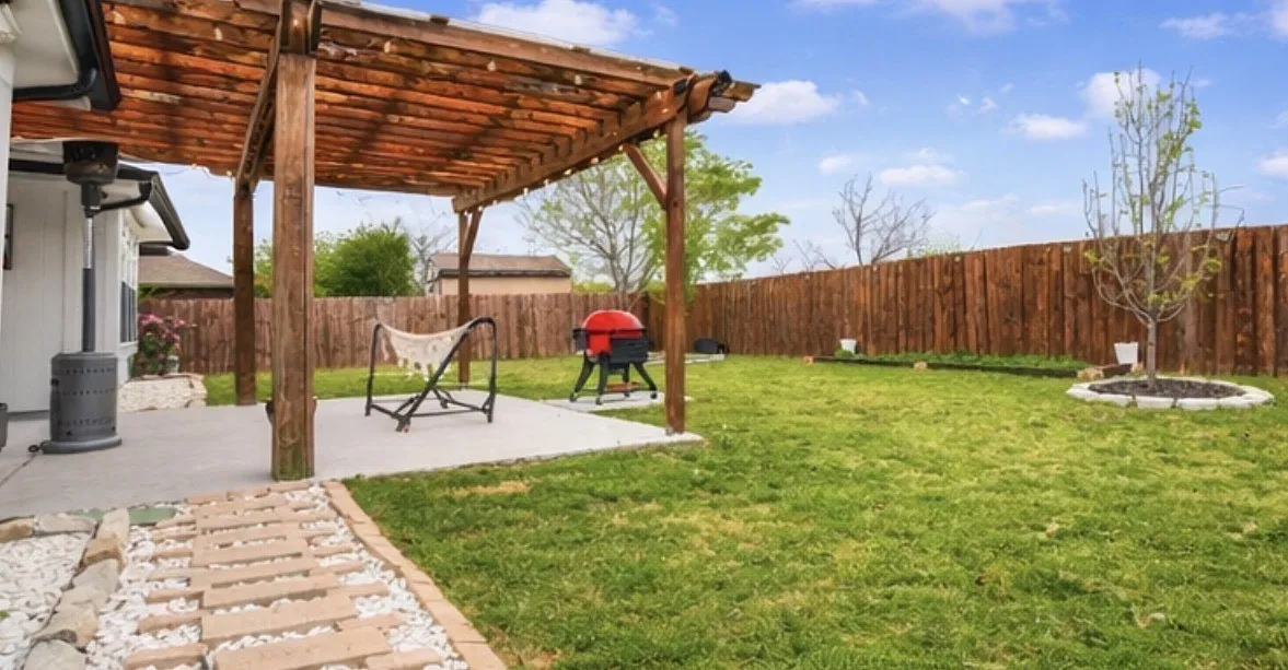Fenced backyard with a pergola and a patio