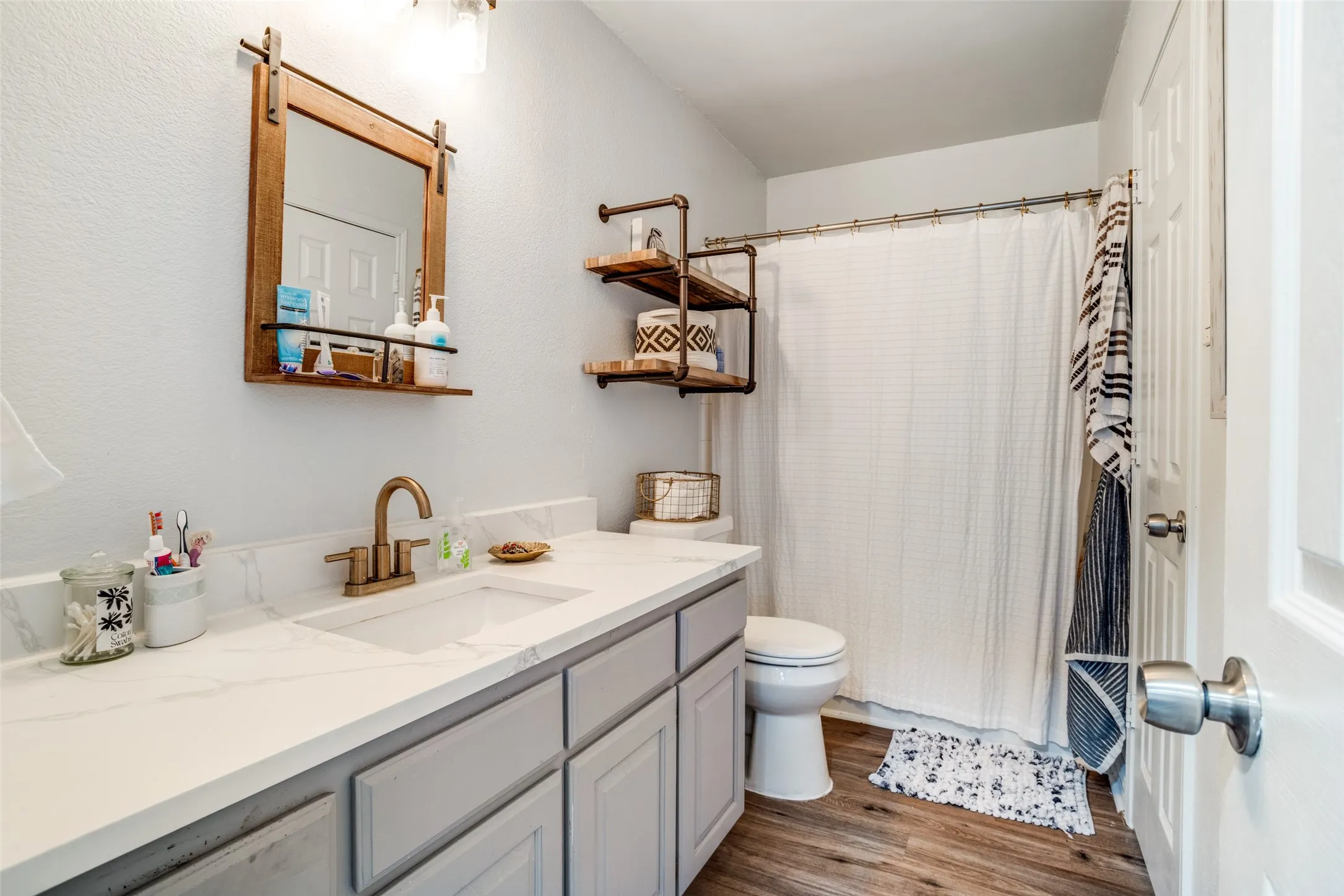 Bathroom featuring vanity, light wood-style floors, and a shower with curtain