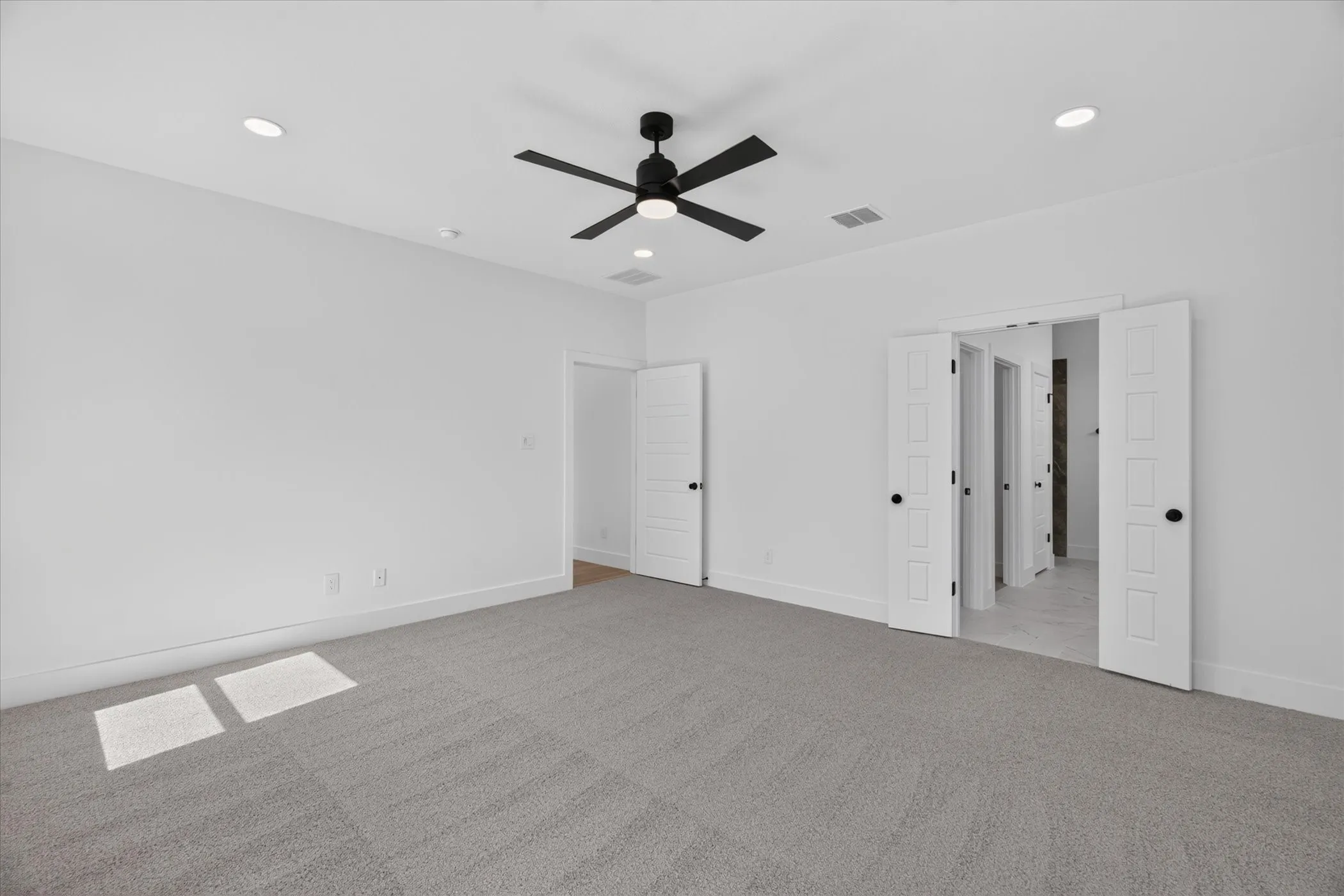 Neutral-toned carpeting, white walls, recessed lighting, and a ceiling fan