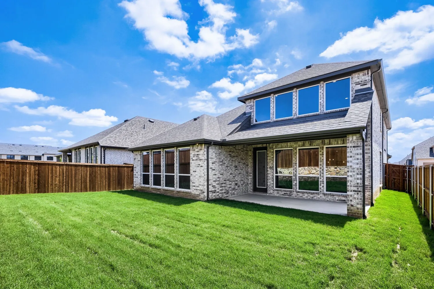 Expansive backyard featuring a manicured lawn and a privacy fence