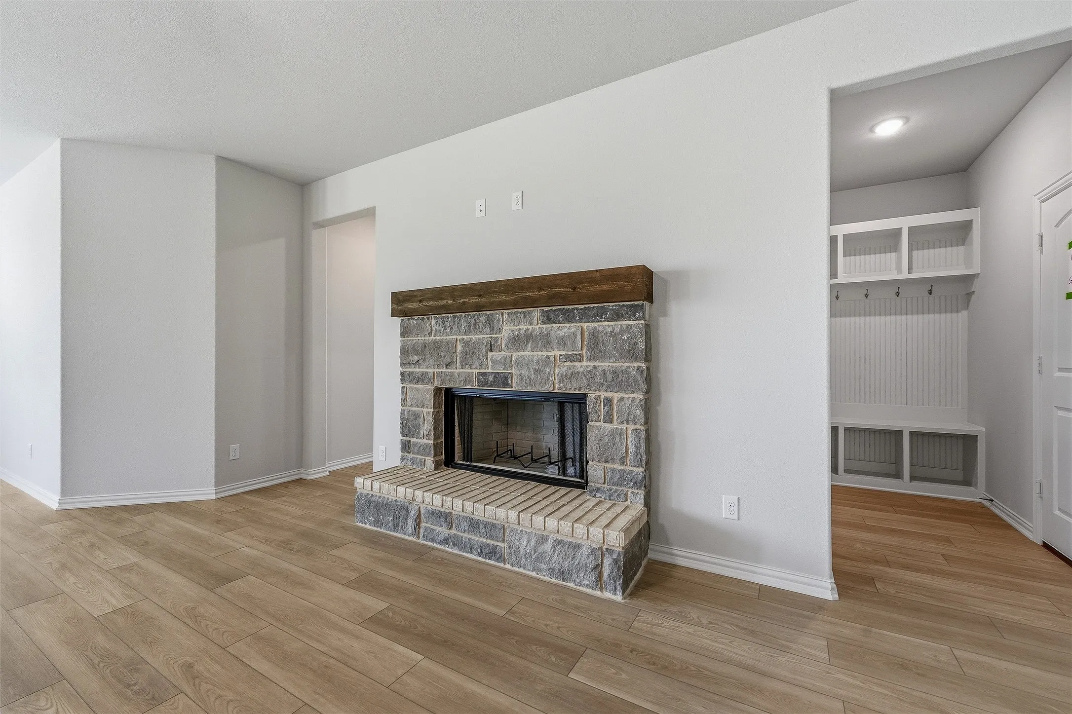 Stone-faced fireplace with a wood mantel and a brick hearth