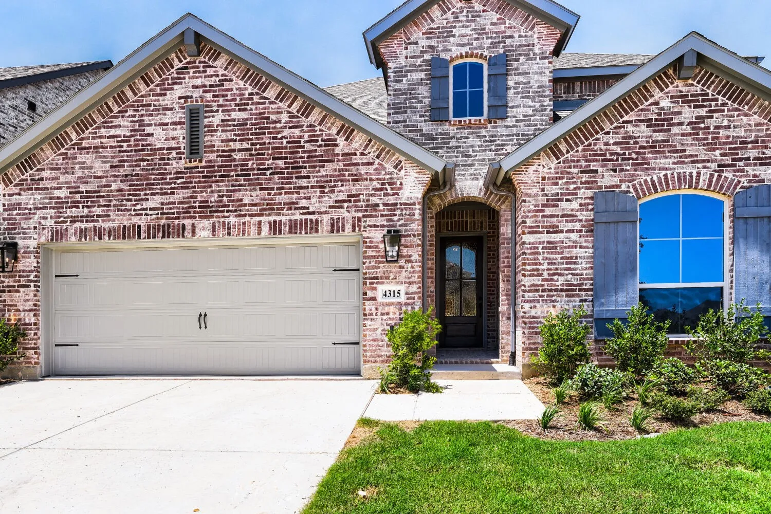 Brick facade featuring architectural gables and a multi-paned front entry door
