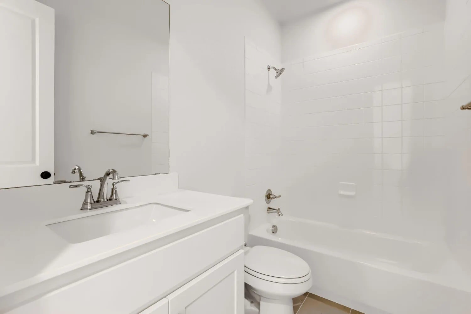 White vanity with an integrated sink, brushed nickel faucet, and a large wall-mounted mirror