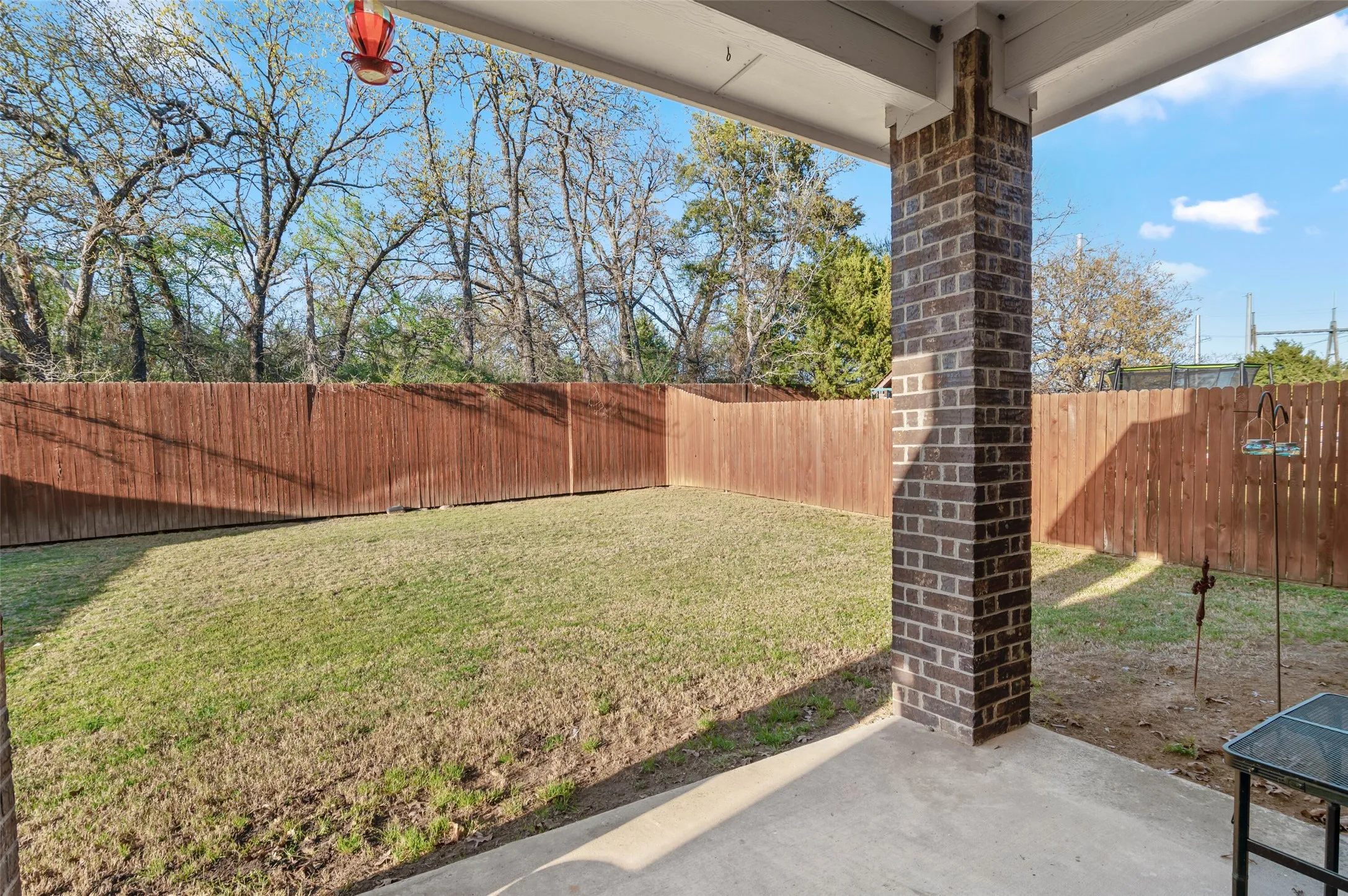 Covered patio overlooking green space behind house