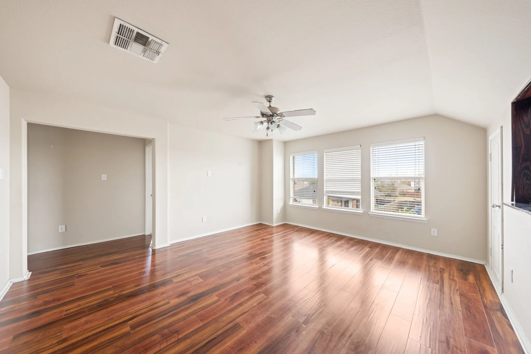 Unfurnished living room featuring dark wood-type flooring and ceiling fan