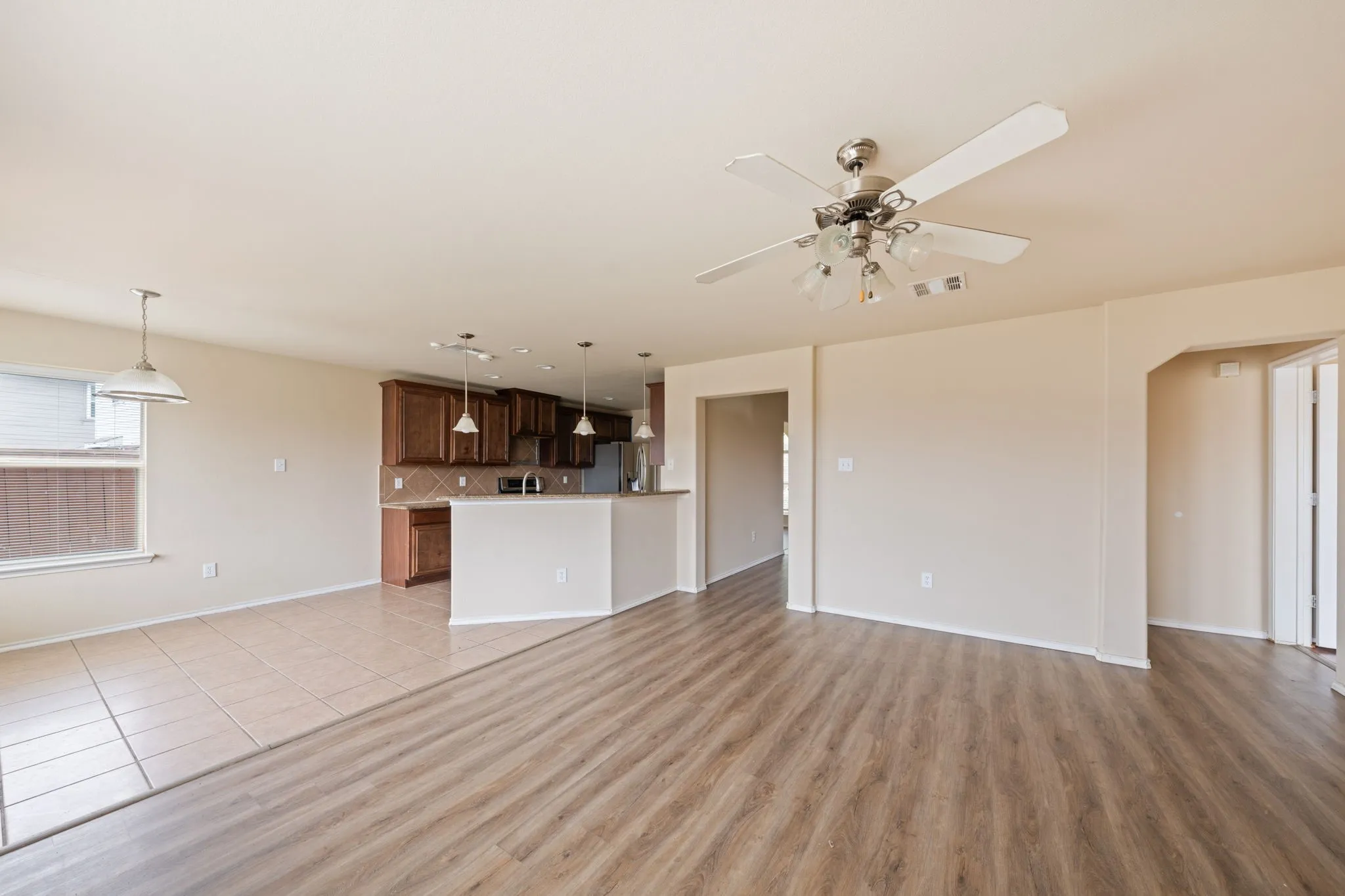 Unfurnished living room featuring light tile patterned floors and ceiling fan