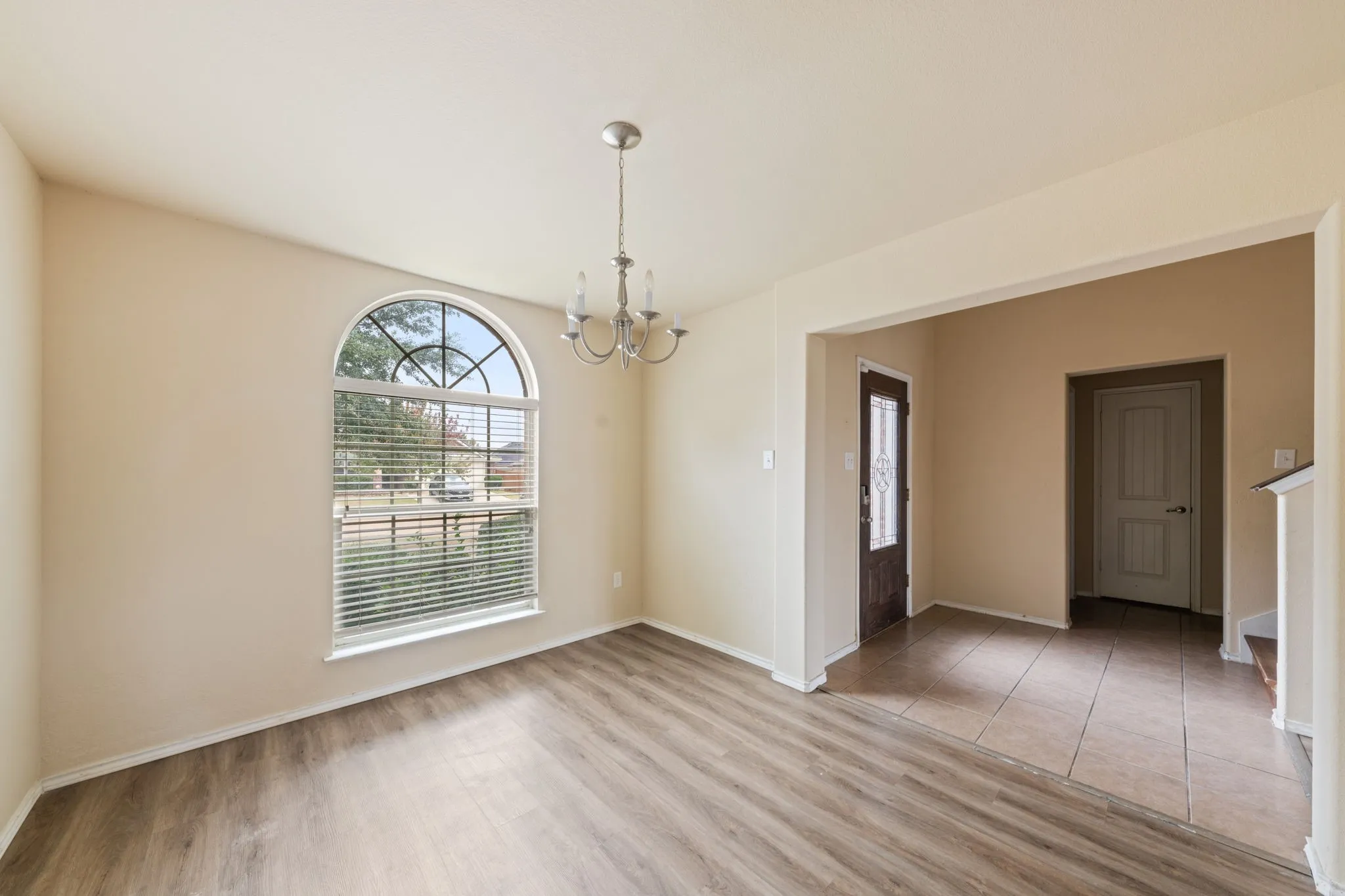 Unfurnished dining area featuring light wood finished floors and a chandelier