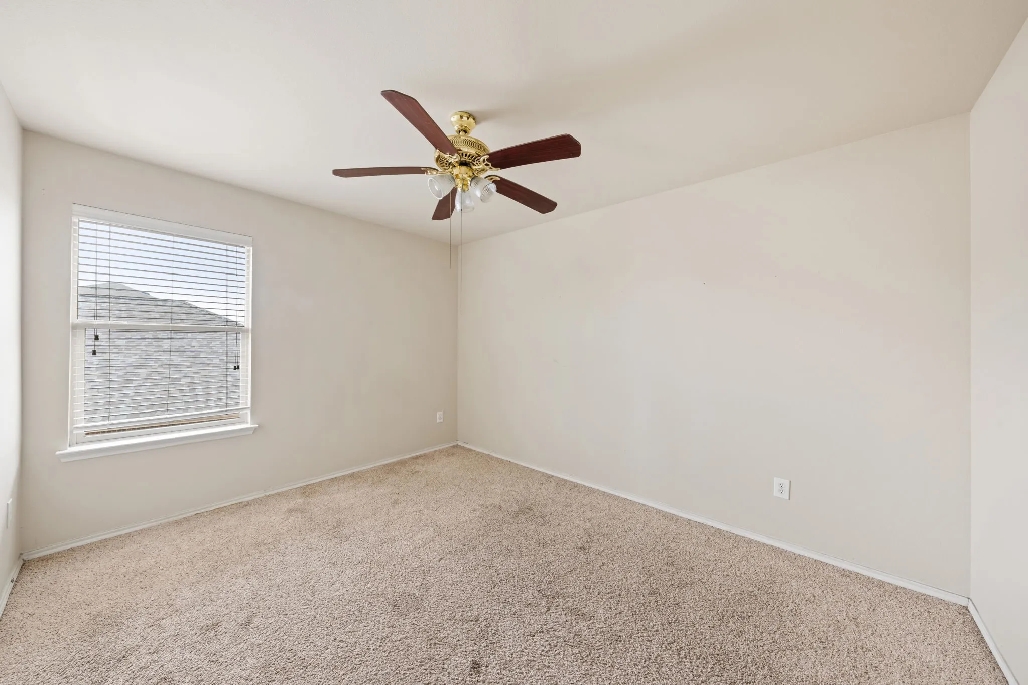 Carpeted empty room featuring a ceiling fan and baseboards