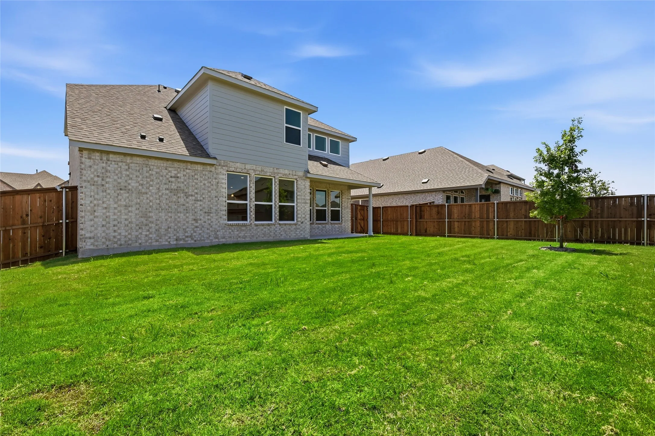 Expansive green lawn defines this backyard space